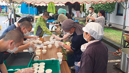 避難所で炊き出しの準備をする僧侶ら（6月29日、広安西小学校）