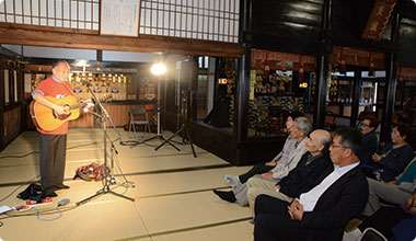 高石ともやさんの名調子に耳をかけむける満堂の参加者。10月11日光明寺本堂にて