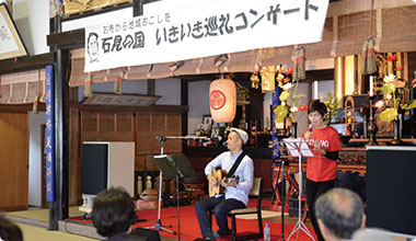 石見で活躍する山根健嗣さんと一緒に歌う良忠寺住職(右)。良忠寺では11月から娘さんが指導するヨガ教室も開始した