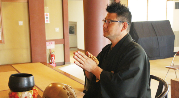 お寺の本堂で手を合わせる